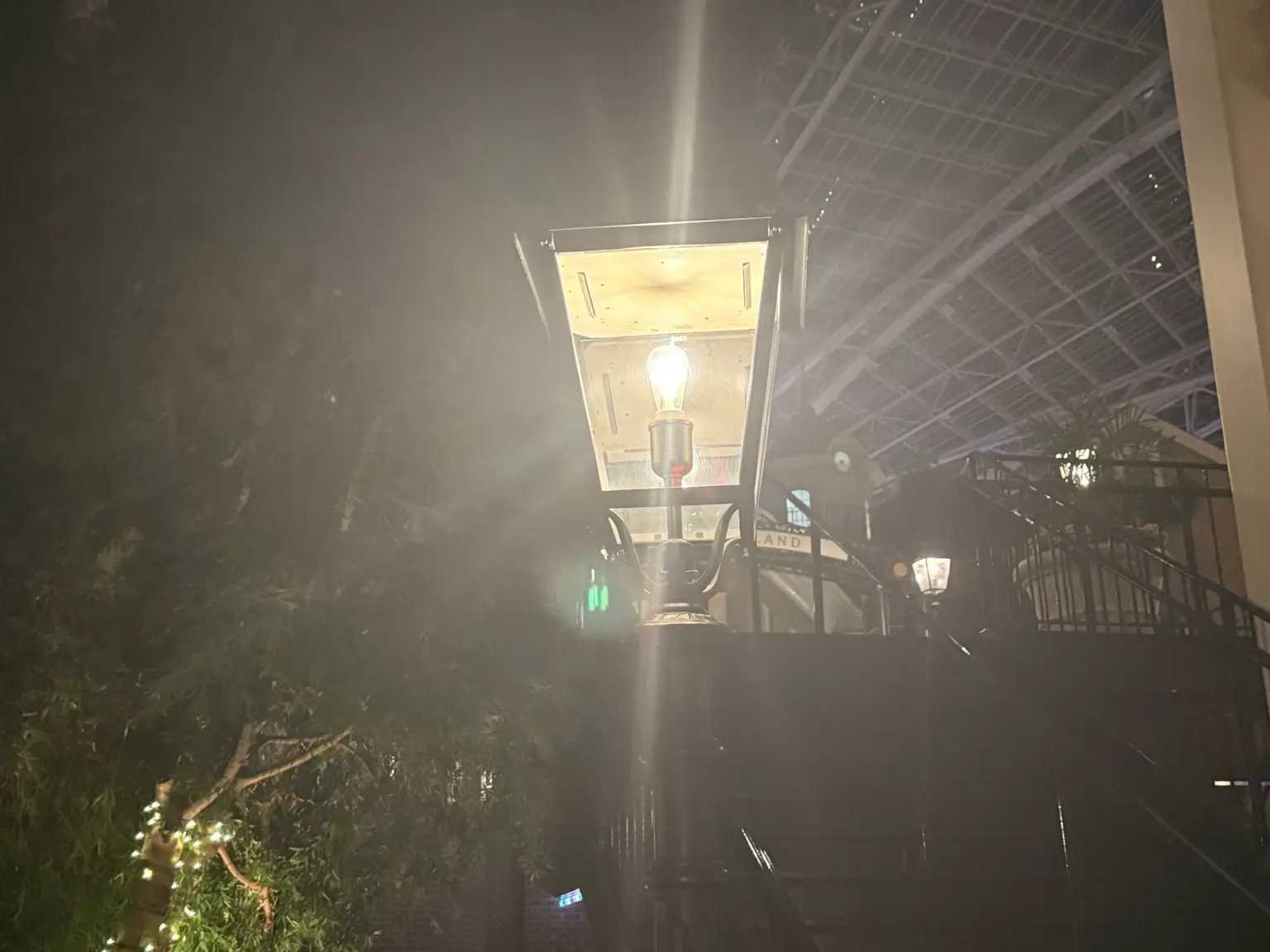 Bright outdoor post lantern creating glare and light spill at night