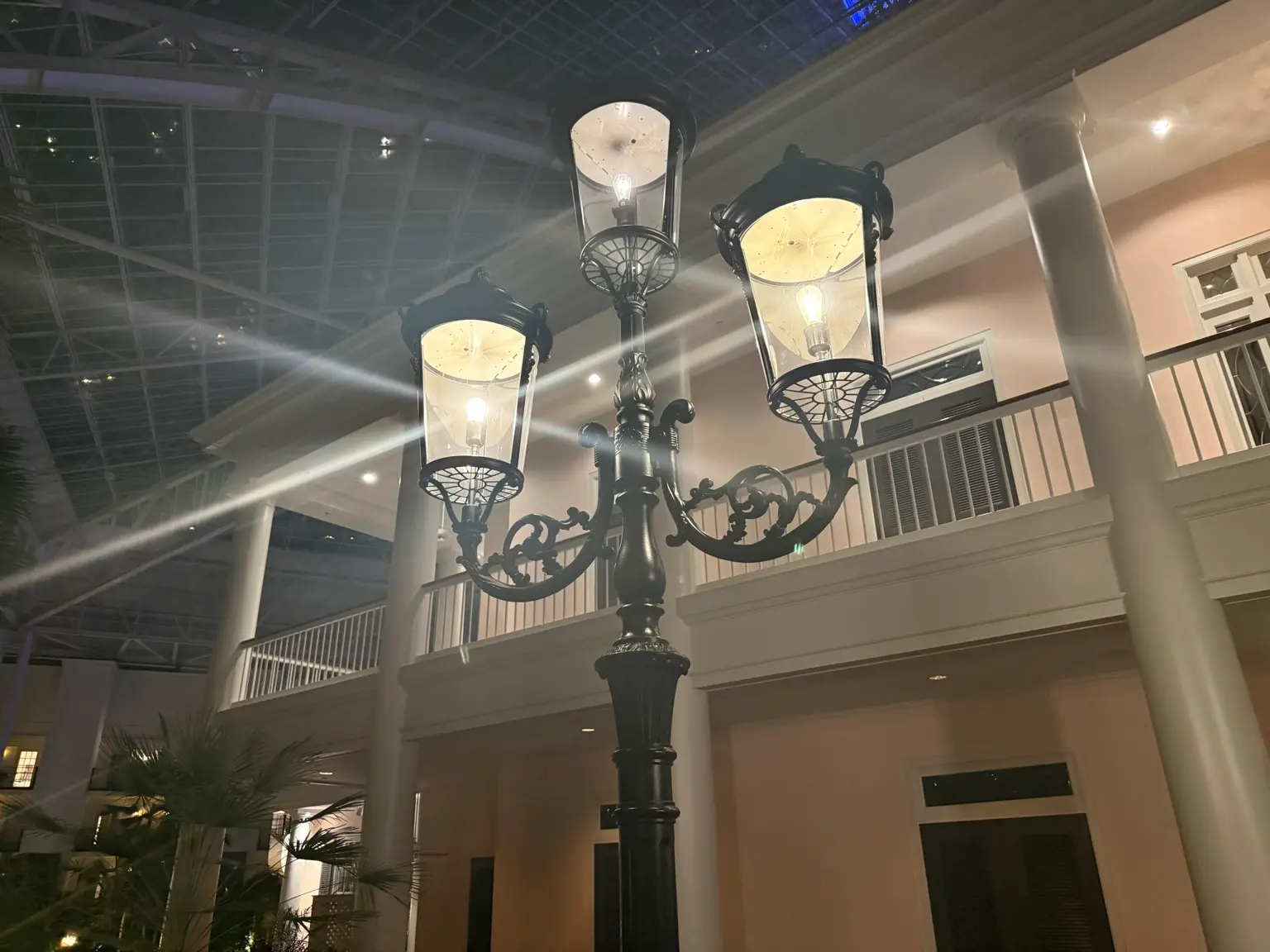 Outdoor post lantern showing bright bulb glare and warm exterior lighting around columns