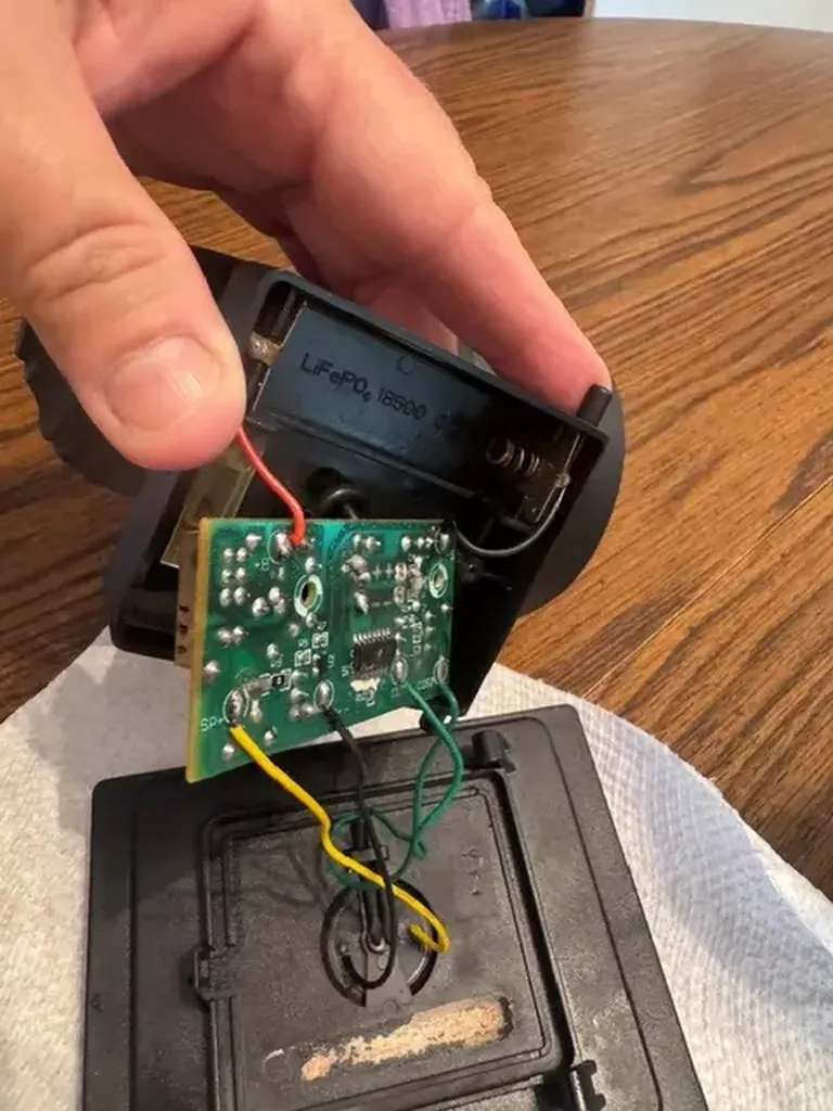 Inside a Portfolio solar landscape light showing the LED driver circuit board, rechargeable battery compartment, and internal wiring during repair