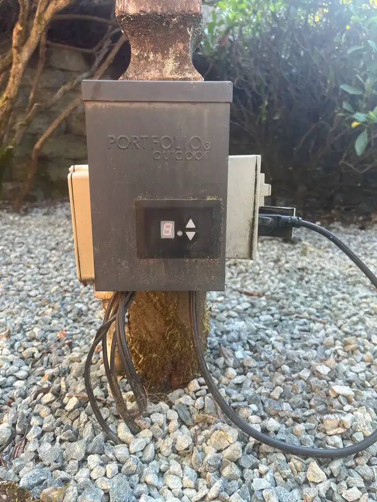 Older Portfolio landscape lighting transformer showing a single-digit timer display set to 8 with up and down programming buttons