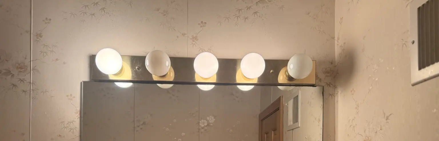 Vanity light fixture with mixed warm and cool LED bulbs demonstrating poor color rendering and inconsistent color temperature