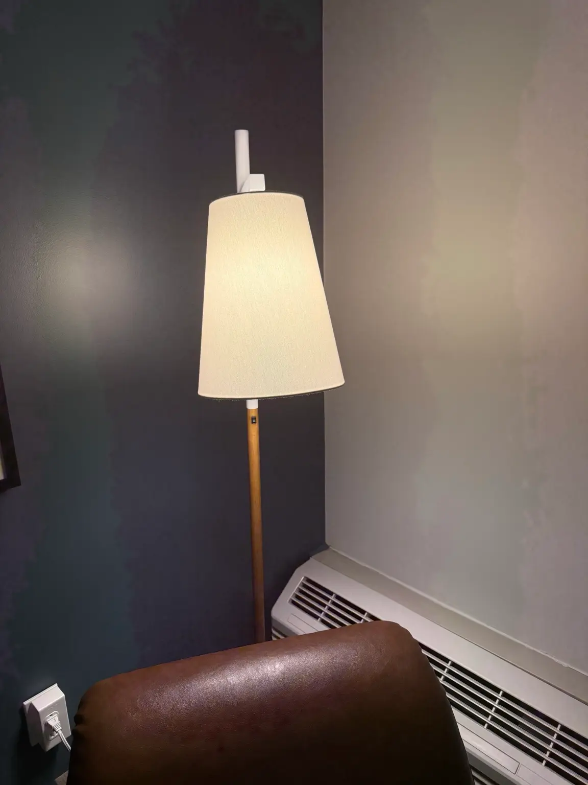 Warm floor lamp beside a chair showing comfortable task lighting for a reading corner