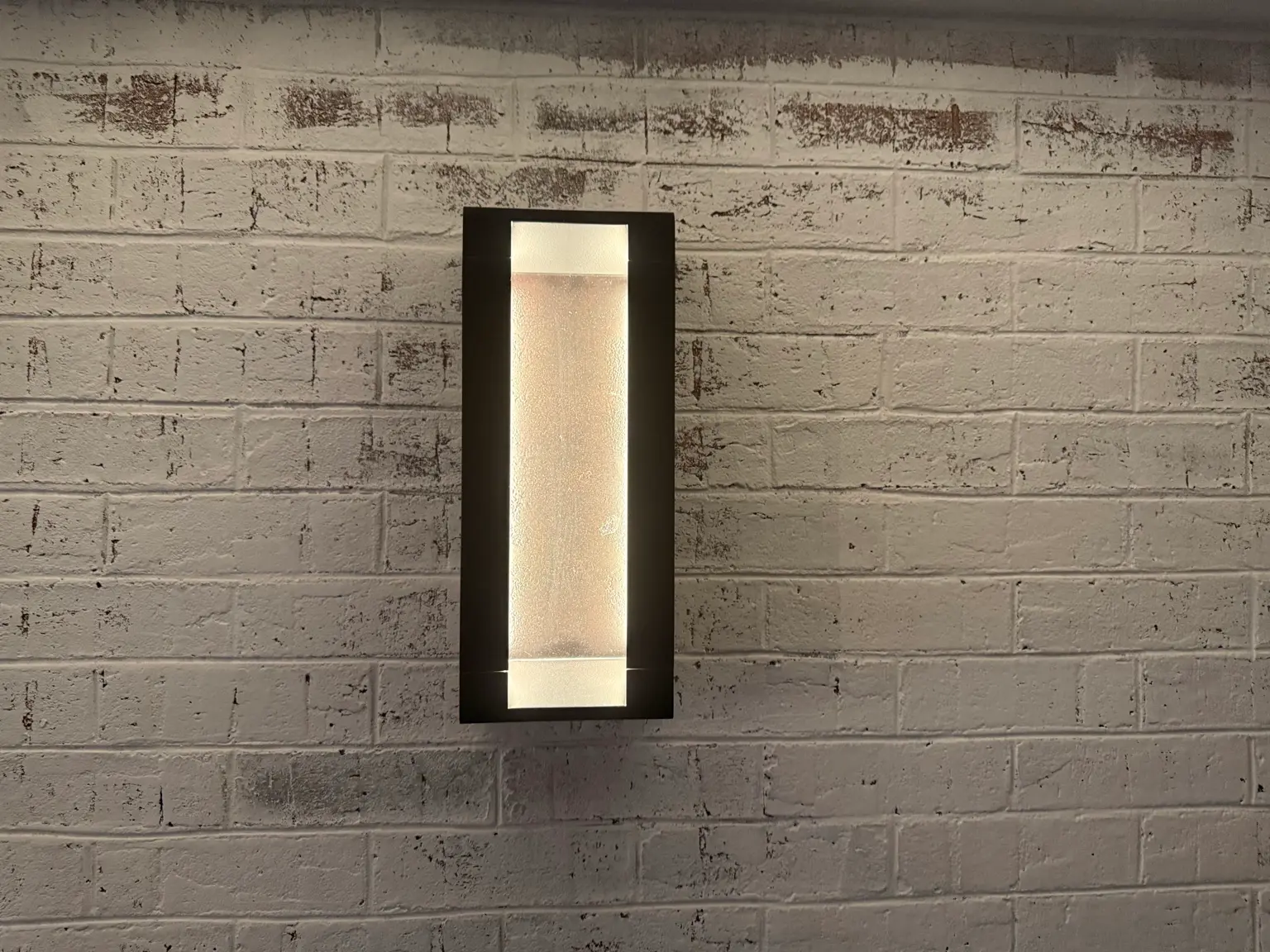 Warm wall sconce mounted on brick wall showing soft indoor accent lighting
